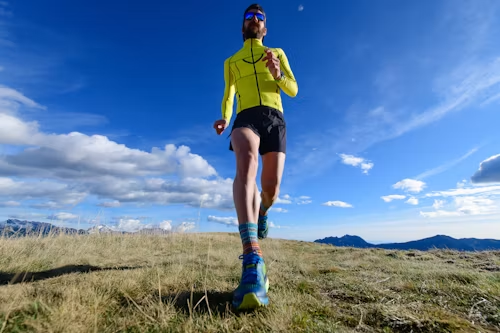 Un coureur de montagne dans un pré s'entraine pour un marathon