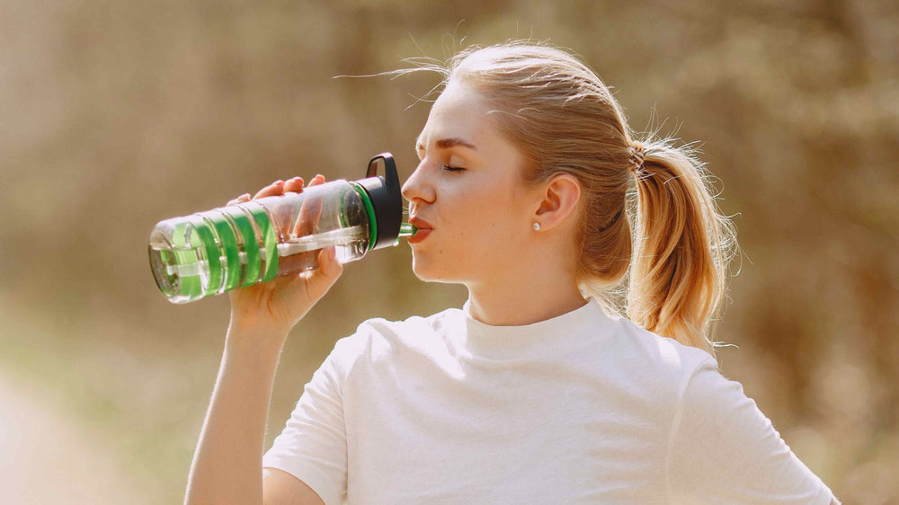 femme qui s'hydrate après séance de sport